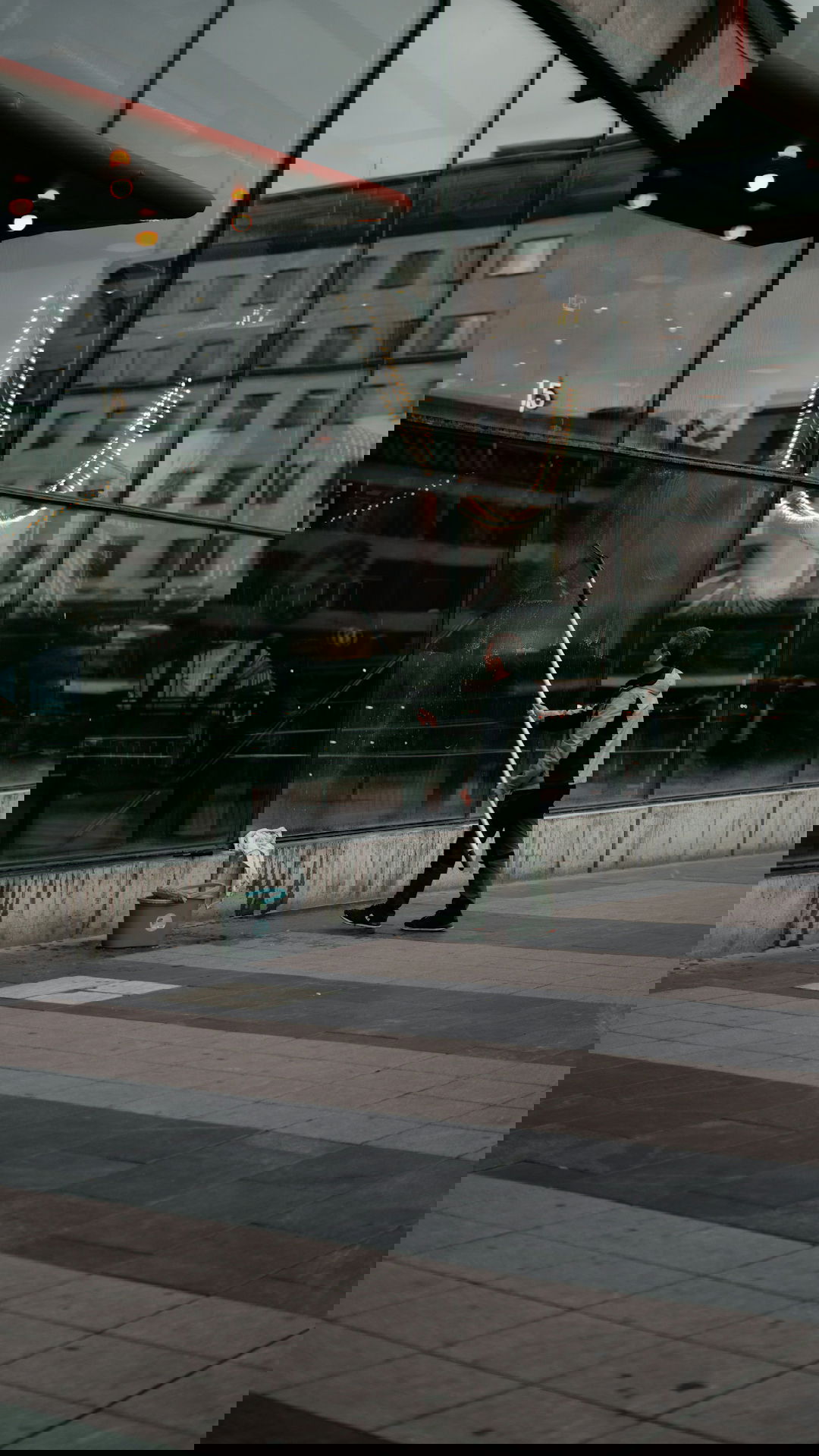 a person holding a large metal pole in front of a building